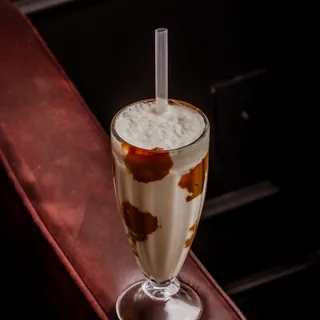 Taça alta de milkshake de sucrilhos com doce de leite escorrido