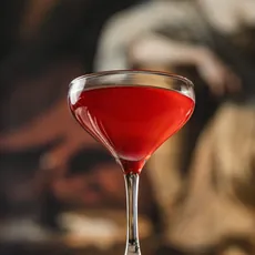 Taça vermelha de Quase Cosmopolitan com pintura clássica desfocada ao fundo
