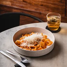 Prato de rigatoni alla vodka com queijo ralado por cima