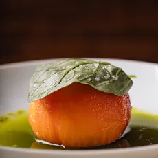 Tomate concassé com folha de manjericão e azeite, servido em prato branco