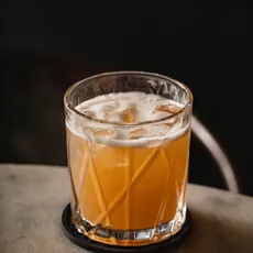 Copo baixo de Whisky Sour Zero sobre mesa de pedra