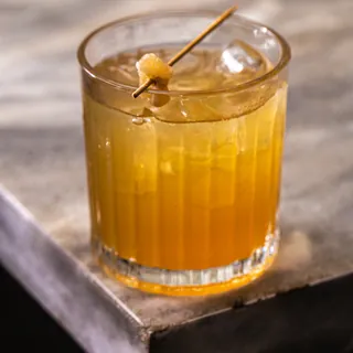 Copo do drink sem álcool Zero Penicilin com espeto de gengibre cristalizado